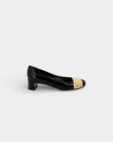 Black patent leather pumps with gold toe caps