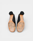 Black patent leather pumps with gold toe caps